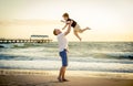 Young happy father holding up in his arms little son putting him up at the beach Royalty Free Stock Photo