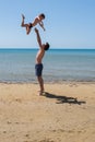 Young happy father holding up in his arms little son putting him up at the beach. Royalty Free Stock Photo