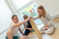 Young happy father playing with his two cute children with wooden blocks