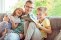 Young happy father reading book with cute children at home Royalty Free Stock Photo