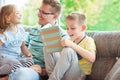 Young happy father reading book with cute children at home Royalty Free Stock Photo