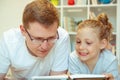 Young happy father reading book with  cute daughter at home Royalty Free Stock Photo