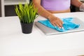 Young Happy Female Janitor Cleaning Desk With Rag In Office Royalty Free Stock Photo