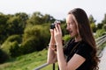 Young happy female photographer walks in the Park with retro camera