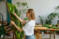 Young happy florist decorator creating plant moss panel Royalty Free Stock Photo