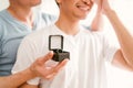 Young happy gay couple in love, proposing a marriage surprise with a wedding ring in the living room at home. Gay men proposal Royalty Free Stock Photo