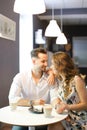 Young happy girl and boy sitting at cafe, drinking coffee and resting. Royalty Free Stock Photo