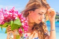 Young happy girl with flower bouquet on tropical sea and beach Royalty Free Stock Photo