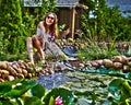 Young happy girl with garden streamlet near pond Royalty Free Stock Photo