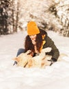 Young happy girl has fun playing with her dog in winter outdoors Royalty Free Stock Photo