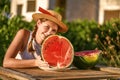 Young happy girl with hat and half of red fresh watermelon enjoying a outdoors. Teenager enjoying summer life Royalty Free Stock Photo