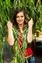 Young happy girl in the leaves of the willow Royalty Free Stock Photo