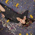 Young happy girl lies on the floor with a donut and sweets are spinning above her