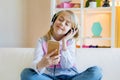 Young happy girl listening music in headphones with closed eyes Royalty Free Stock Photo