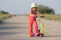 Young happy girl on scooter on road Royalty Free Stock Photo