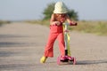 Young happy girl on scooter on road