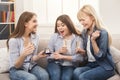 Young happy girl showing her proposal ring to surprised girlfriends Royalty Free Stock Photo