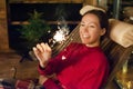 Young happy girl with sparkler in the evening on the terrace of the house. Holiday christmas and new year Royalty Free Stock Photo