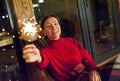 Young happy girl with sparkler in the evening on the terrace of the house. Holiday christmas and new year Royalty Free Stock Photo