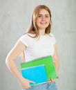 Young happy girl student hold books on gray background studio portrait. Education in high school university college Royalty Free Stock Photo
