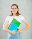 Young happy girl student hold books on gray background studio portrait. Education in high school university college Royalty Free Stock Photo