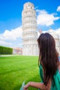 Young happy girl with toristic map on travel to Pisa. Tourist traveling visiting The Leaning Tower of Pisa. Royalty Free Stock Photo