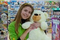 A young happy girl 20 -25 years old, a seller in a children`s toy store. Favorite work. Portrait of a woman, positive emotions.