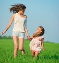 Young happy girls running at green wheat field Royalty Free Stock Photo