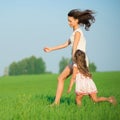 Young happy girls running at green wheat field Royalty Free Stock Photo