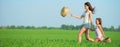 Young happy girls running witch baskets at green wheat field Royalty Free Stock Photo