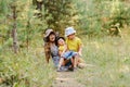 Young happy grandmother with two grandchildren sitting on a fore