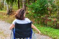 Young happy handicap woman in wheelchair on road in hospital park enjoying freedom. Paralyzed girl in invalid chair for disabled Royalty Free Stock Photo