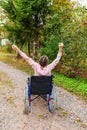 Young happy handicap woman in wheelchair on road in hospital park enjoying freedom. Paralyzed girl in invalid chair for disabled Royalty Free Stock Photo