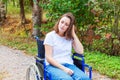 Young happy handicap woman in wheelchair on road in hospital park waiting for patient services. Paralyzed girl in invalid chair Royalty Free Stock Photo