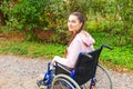 Young happy handicap woman in wheelchair on road in hospital park waiting for patient services. Paralyzed girl in invalid chair Royalty Free Stock Photo