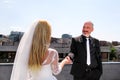 Young happy handsome wedding couple stands on the roof. Royalty Free Stock Photo