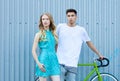 Young happy hipster couple in love meet each other and dating whis bicycle. Pretty blonde caucasian woman with her hispanic Royalty Free Stock Photo