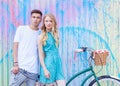 Young happy hipster couple in love meet each other and dating whis vintage bicycle. Pretty blonde caucasian woman with her