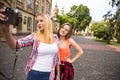 Young happy hipster teenage girls taking pictures and having fun in summer park Royalty Free Stock Photo
