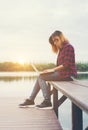 Young happy hipster woman working with her laptop sitting on pie Royalty Free Stock Photo