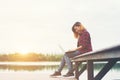 Young happy hipster woman working with her laptop sitting on pie Royalty Free Stock Photo