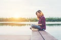 Young happy hipster woman working with her laptop sitting on pie Royalty Free Stock Photo