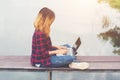 Young happy hipster woman working with her laptop sitting on pie Royalty Free Stock Photo