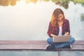 Young happy hipster woman working with her laptop sitting on pie Royalty Free Stock Photo