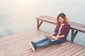 Young happy hipster woman working with her laptop sitting on pie Royalty Free Stock Photo