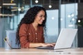 Young and happy hispanic woman working in modern office using laptop, business woman smiling and happy in glasses and Royalty Free Stock Photo