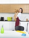 Young and happy housewife hugs her lovely pet after cleaning