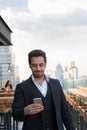 Young happy Indian businessman smiling while using mobile phone Royalty Free Stock Photo