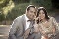 Young happy Indian couple sitting together outdoors Royalty Free Stock Photo