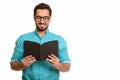 Portrait of young happy Indian man reading book Royalty Free Stock Photo